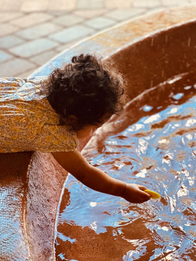 Baby Placing Chip in Fountain